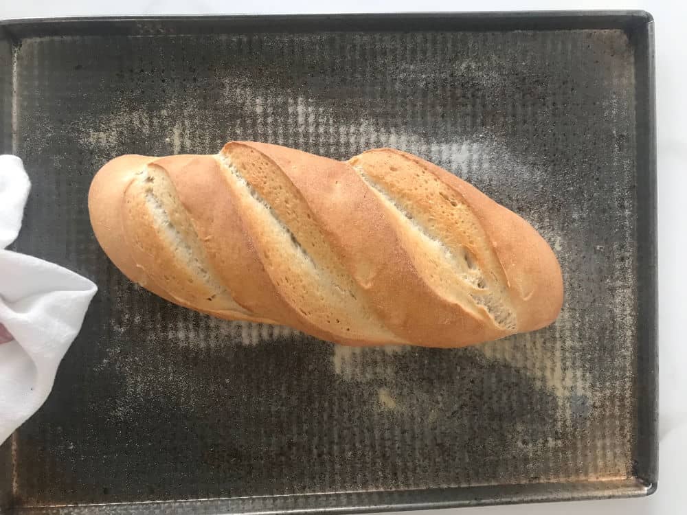 Baked loaf of bread on metal sheet