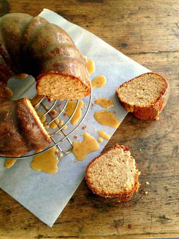 maple walnut pound cake on wire rack, two slices on wooden table