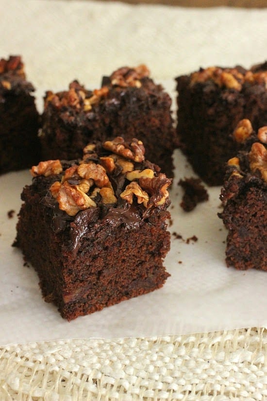 Walnut chocolate cake squares on white paper and cloth