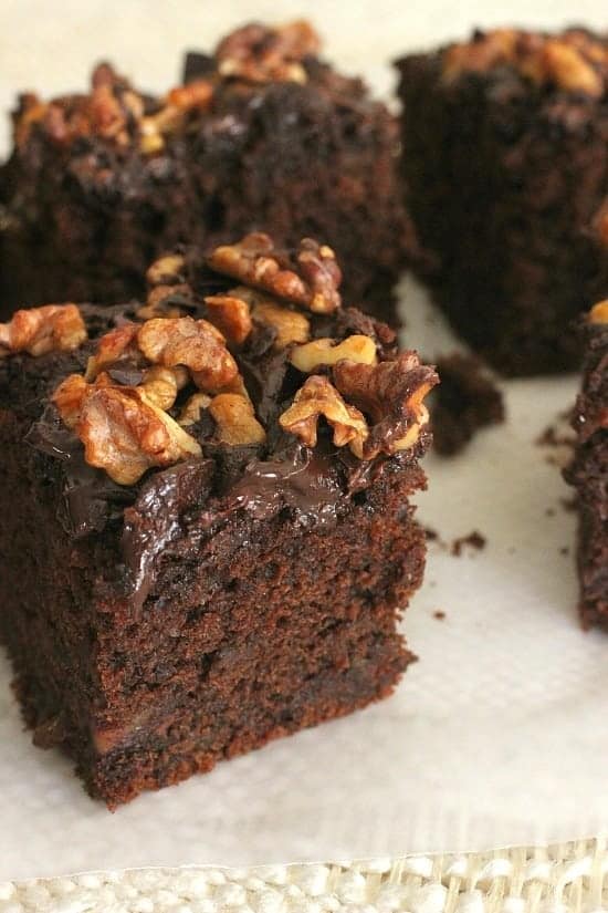 Chocolate date walnut cake squares on a white surface. Close up image. 