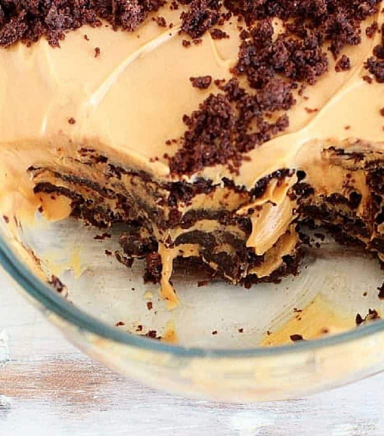 Close up of chocotorta in glass dish with servings missing.