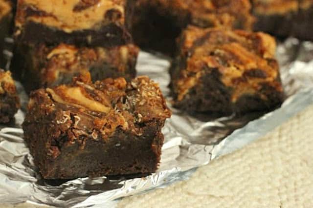 Squares of swirled brownies on aluminum foil surface
