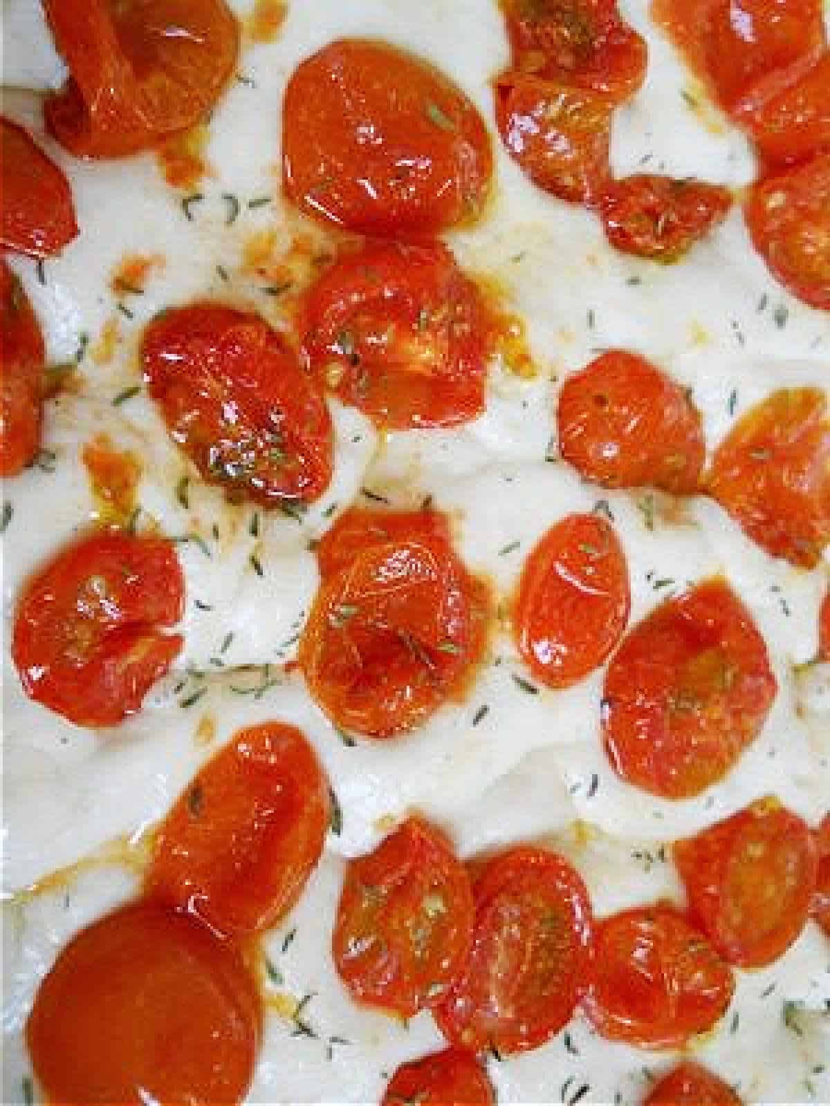 Raw bread dough with cherry tomatoes on top