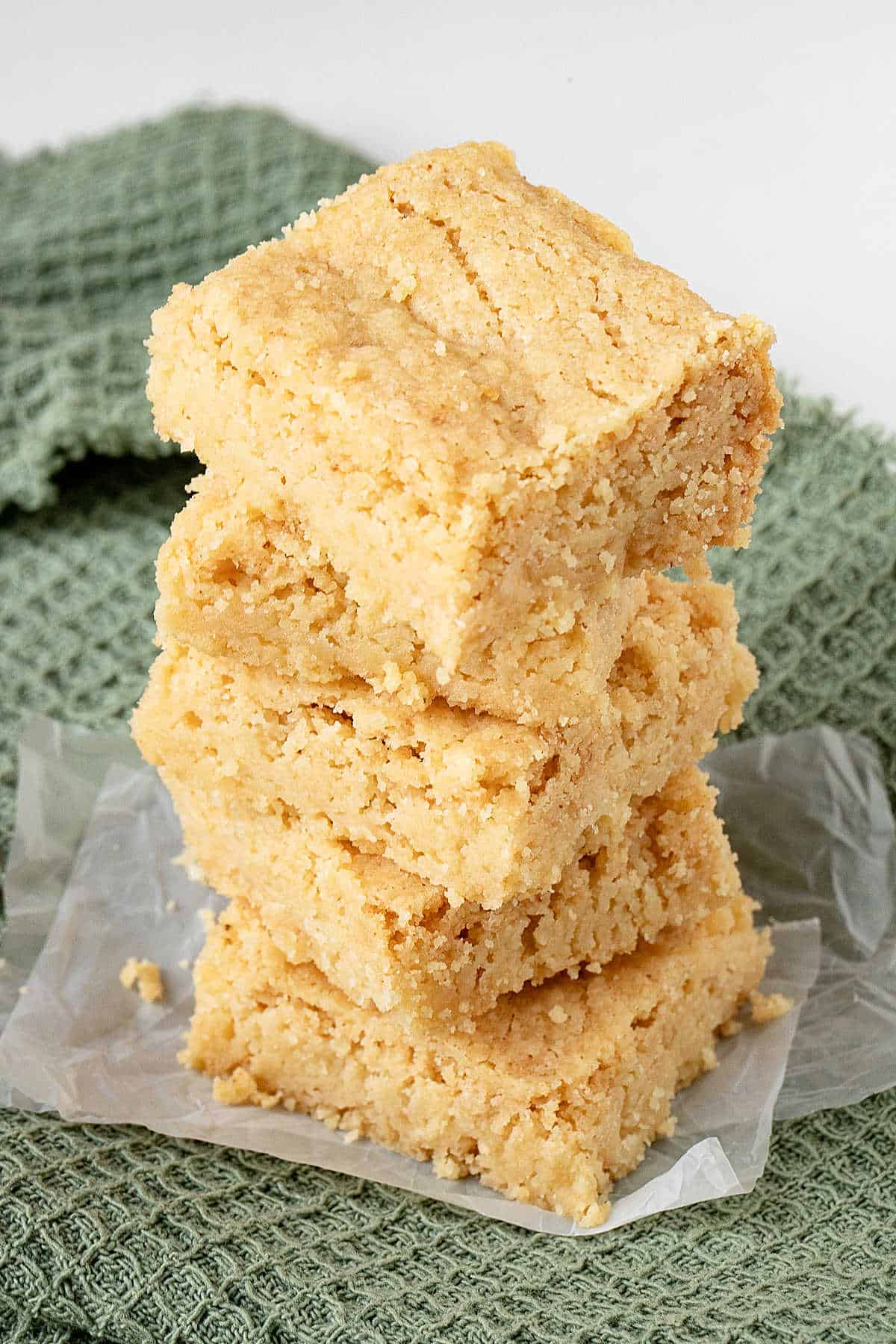 View from above of stack of brown butter shortbread on a plastic square over a green cloth.