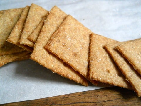 Homemade Wheat Thin Crackers spread on a white piece of paper. 
