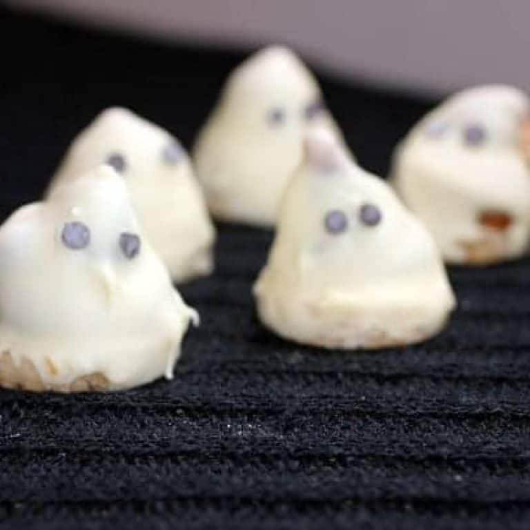 Several white chocolate cones on a black knitted cloth.