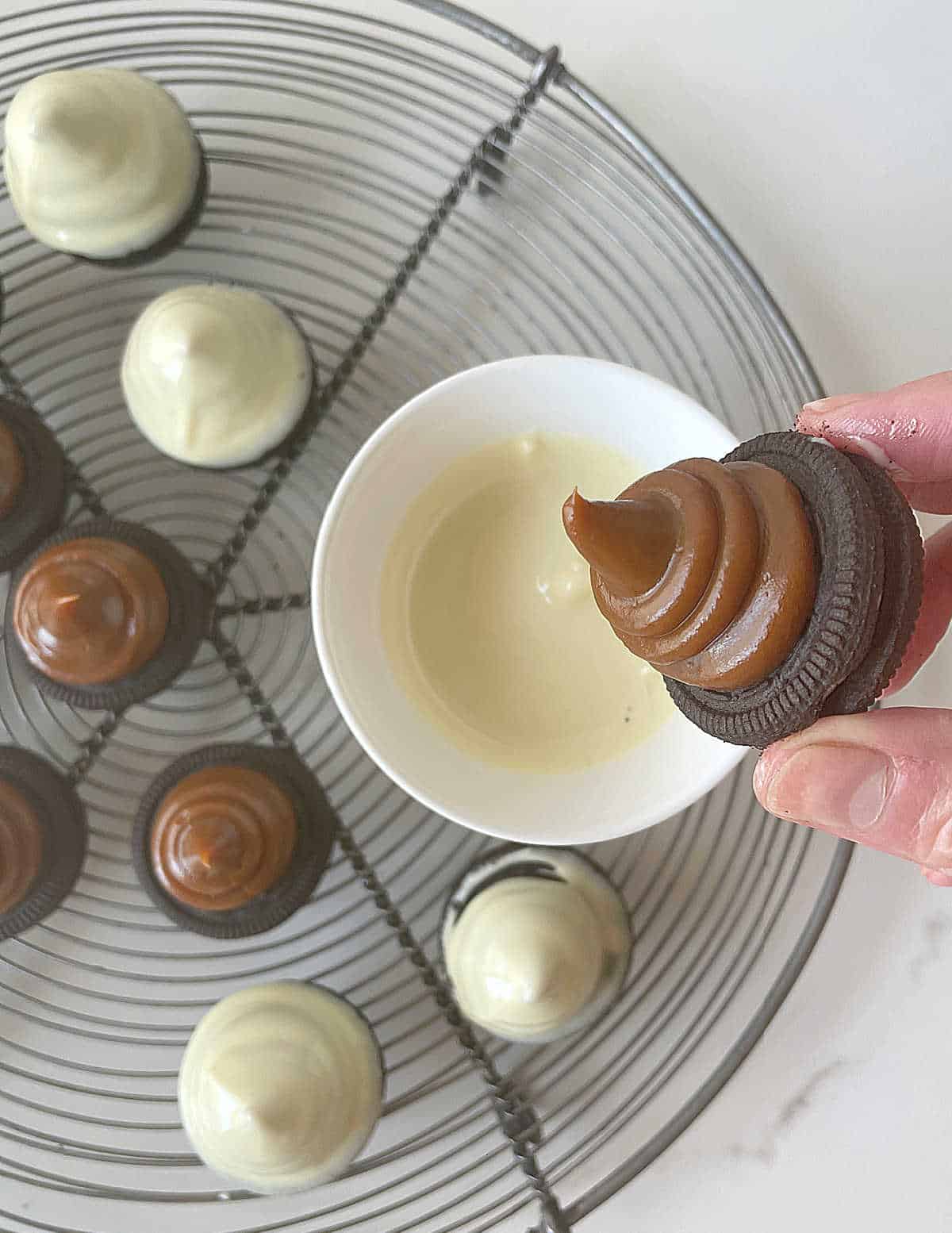 Round wire rack with oreo cookies with dulce de leche and coated with white chocolate. 