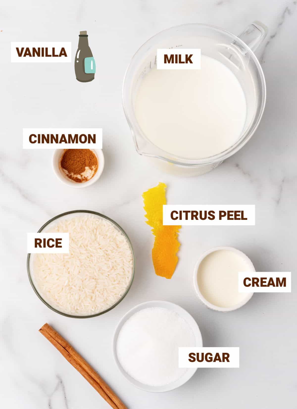 Ingredients for cinnamon rice pudding in bowls on white marble surface, including citrus peel, sugar, milk, vanilla, cream, cinnamon stick.