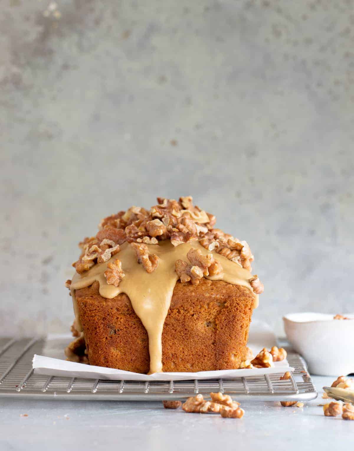 Coffee glazed walnut loaf bread on wire rack, grey background