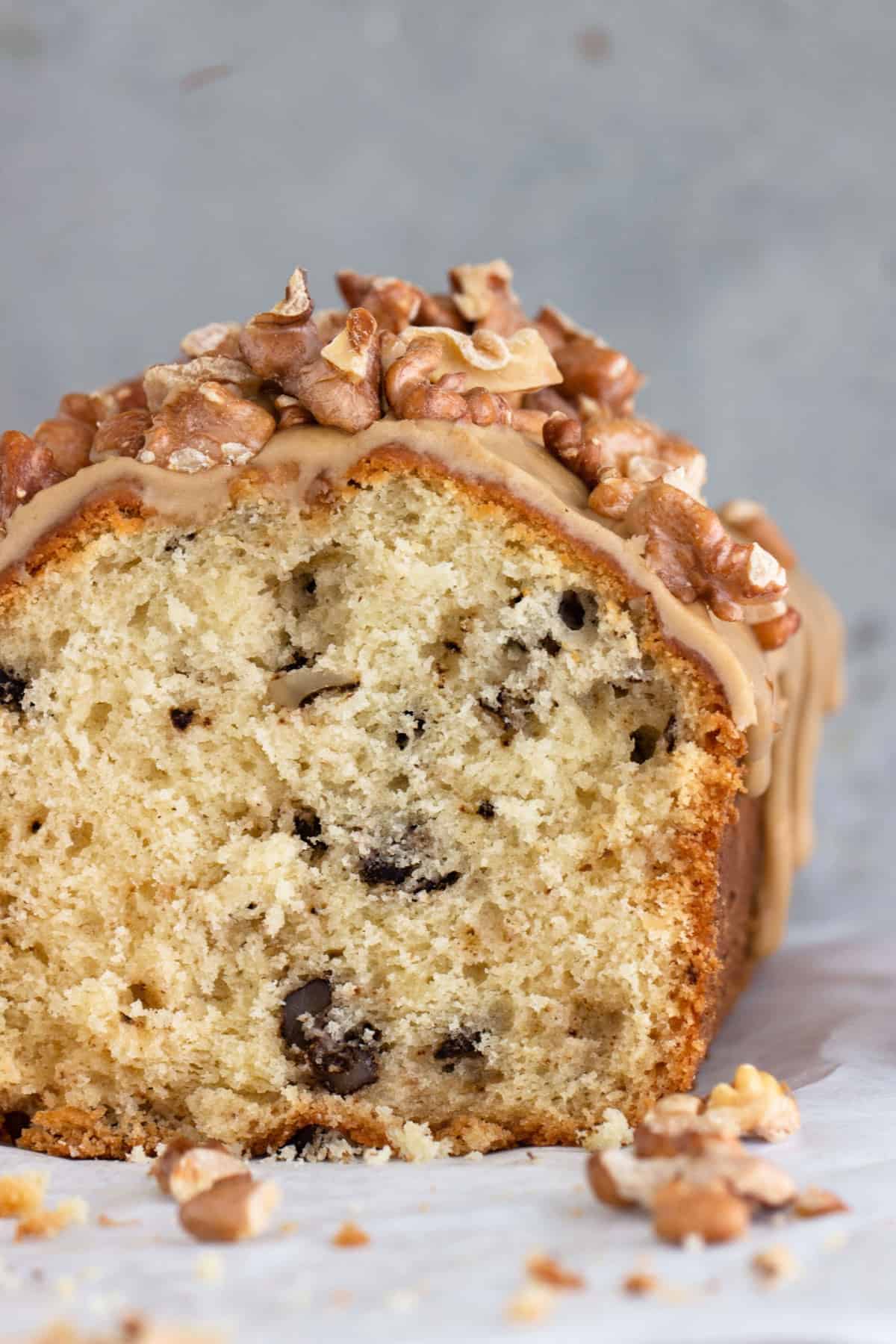 Close-up image of glazed walnut bread crumb, grey background and walnuts.