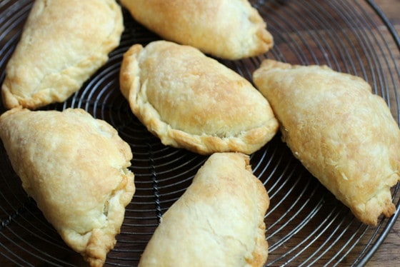 Baked empanadas on metal cooling rack. 