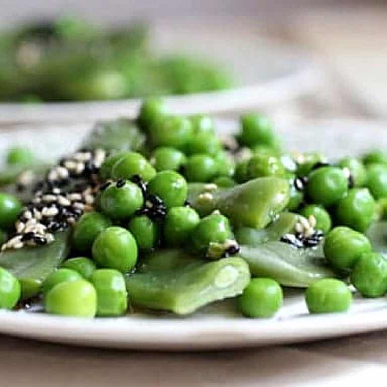 Very close up image of a mound of sesame peas and green beans on a plate.