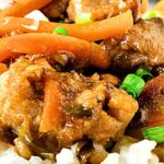 Orange, brown and white text overlay on close-up image of pork carrot stir fry.