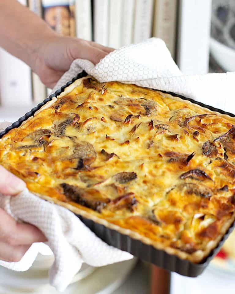 Hands holding square mushroom quiche