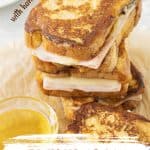 Orange brown and white text overlay on stack of ham and cheese French toast sandwiches.