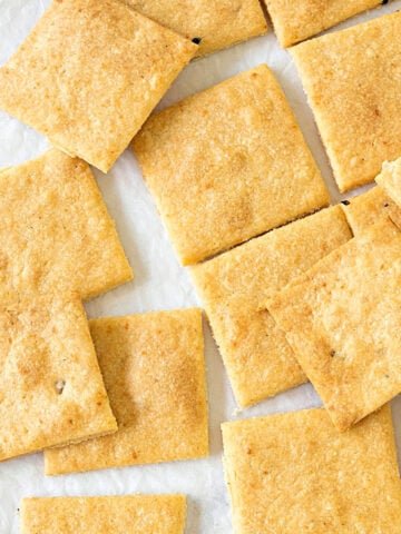 Homemade cheese crackers on a white surface. Close up top view.