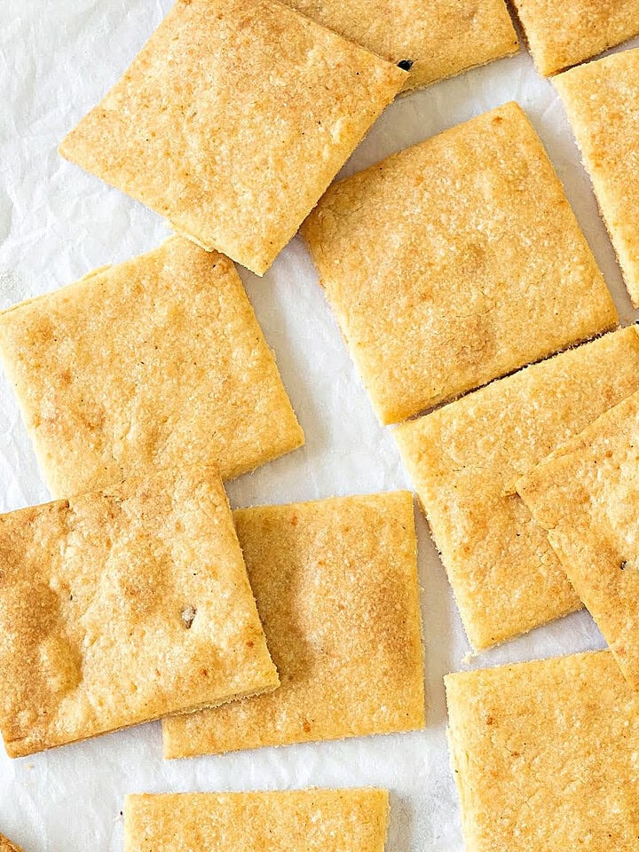 Homemade cheese crackers on a white surface. Close up top view.