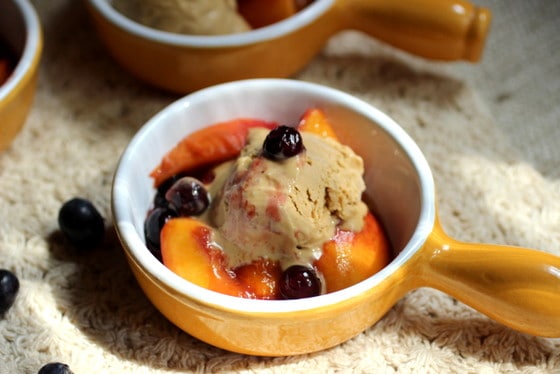 Yellow and white ramekins with brown sugar ice cream topped with summer fruit.