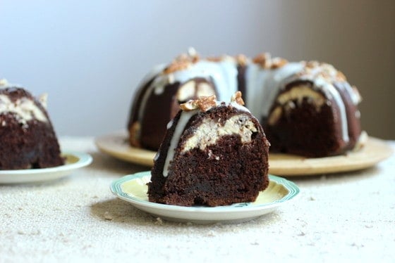 A few pieces of chocolate cheesecake bundt cake in plates, and on wooden board.