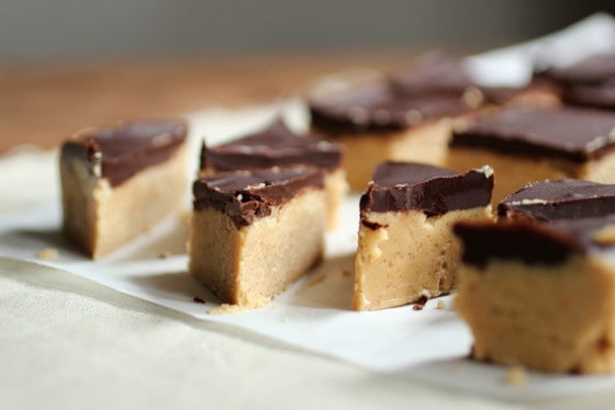 Close-up of triangles of chocolate topped peanut butter fudge on white paper