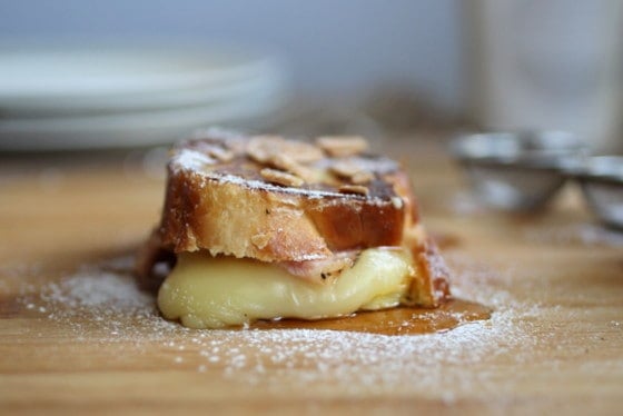 Front view of cheese french toast with powdered sugar on a wooden board.
