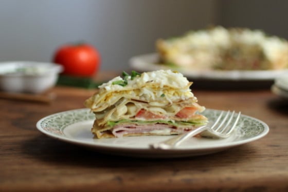 Cut slice of the Savory Crêpe Cake on a plate with fork.