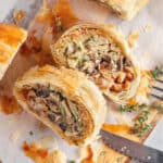 Close up slices of mushroom strudel on white parchment paper. Thyme sprigs.