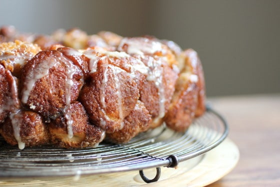 Partial view of monkey bread on a wire rack on a wooden surface. 
