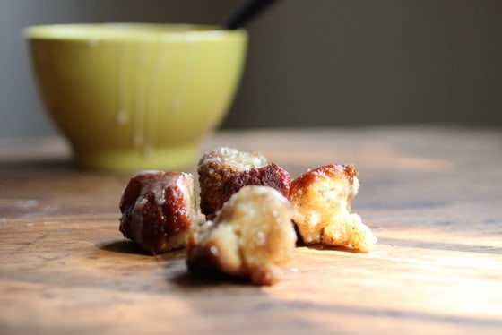 Wooden table with yellow bowl and pieces of monkey bread. 