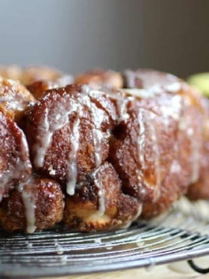 Partial view of iced monkey bread on a wire rack.