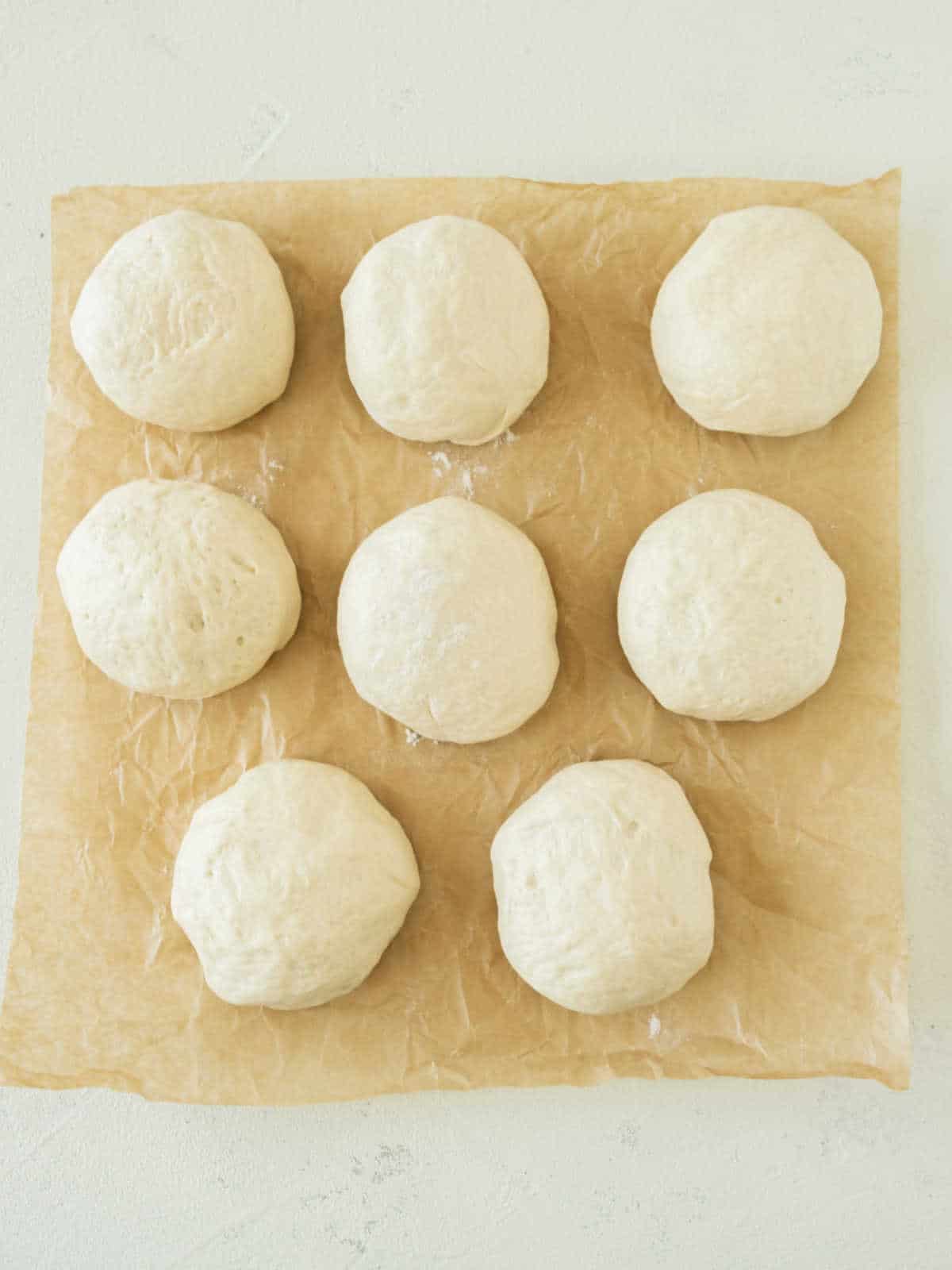 Dough balls on beige parchment paper.