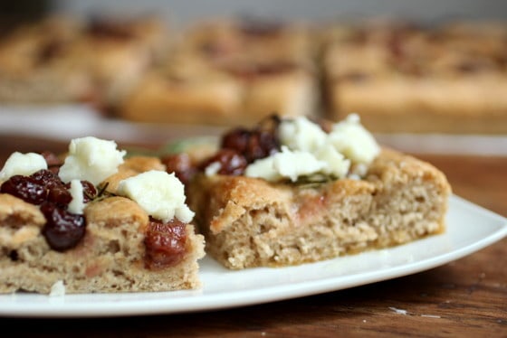 Two squares of Whole Wheat Focaccia with Roasted Grapes and Goat Cheese on a white plate