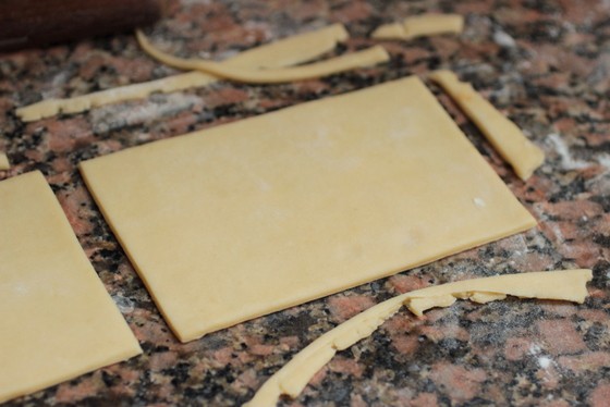 Rectangles of puff pastry on brownish marble surface