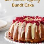 Glazed white chocolate raspberry bundt cake on white plate, grey background, with text