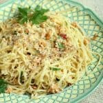 Green white plate with linguini with cauliflower pesto.