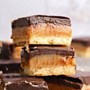 Close up stack of millionaire bars with dark chocolate. Gray background.