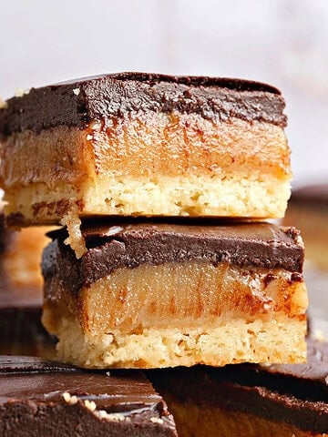 Close up stack of millionaire bars with dark chocolate. Gray background.