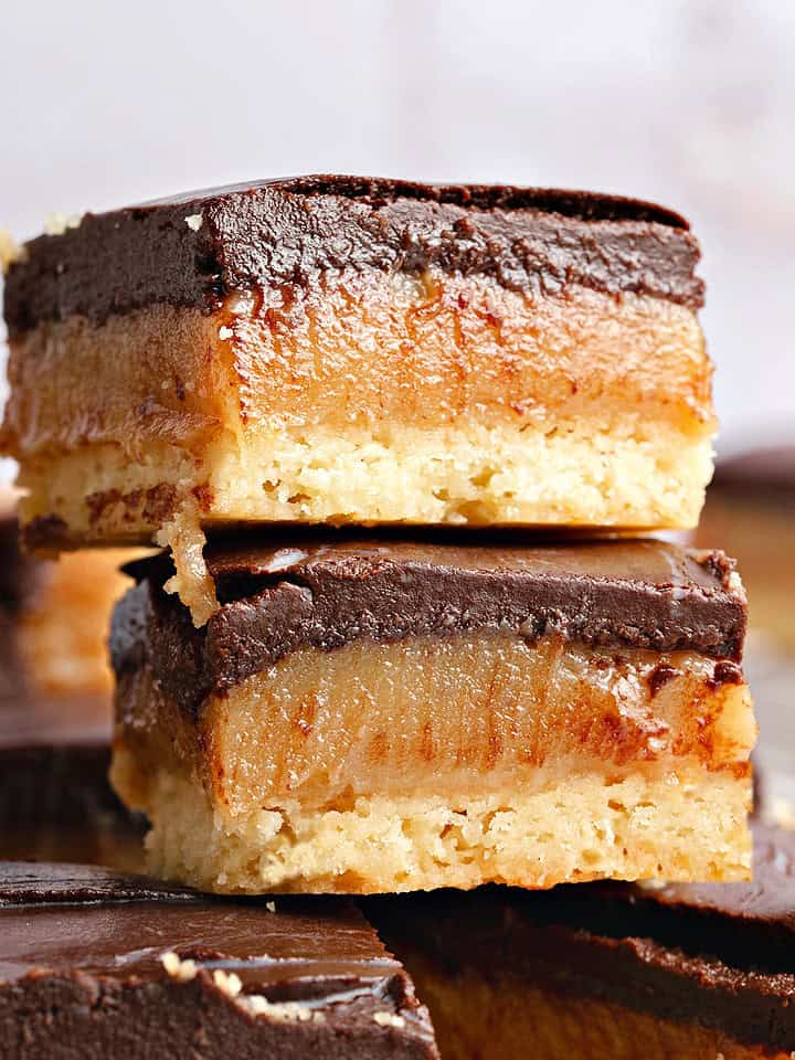 Close up stack of millionaire bars with dark chocolate. Gray background.