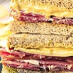 Brown and white text overlay on halved pastrami mustard rye sandwiches.
