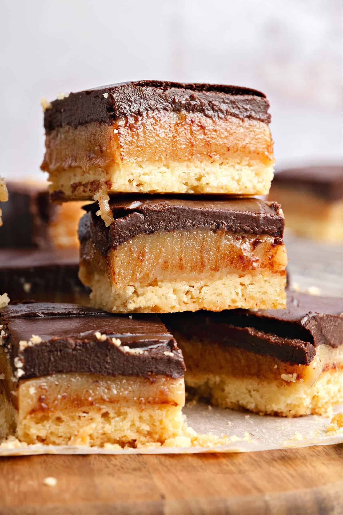 Millionaire bars stacked on a white paper and wooden board. Gray background.