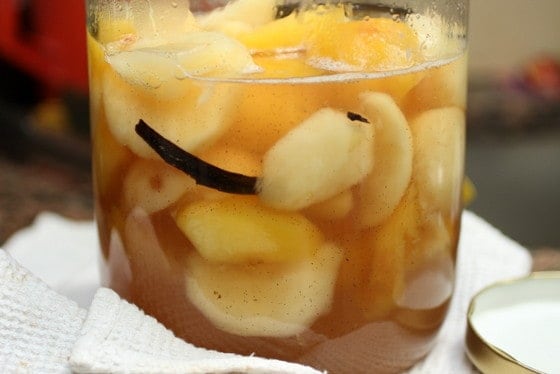 Large glass jar with peaches in syrup