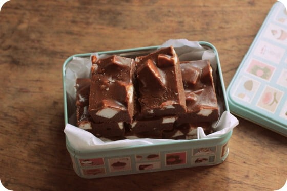 Box with silk paper and chocolate marshmallow fudge pieces on a wooden table