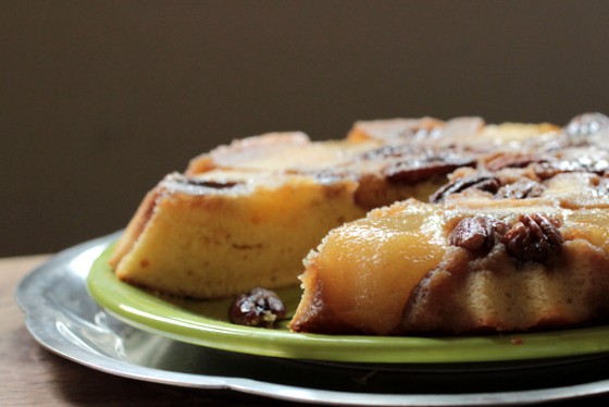 Pear Pecan Upside Down Cake on green plate over silver platter; wooden table