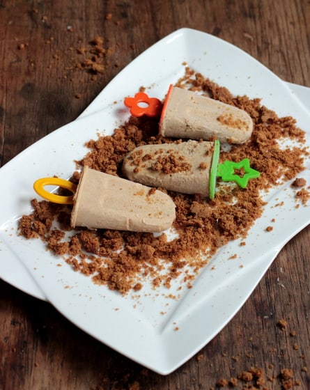 White plate on wooden board with cinnamon popsicles.