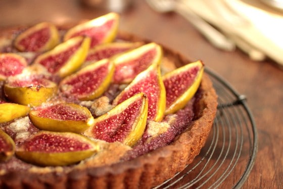 Partial view of fig tart on wire rack on wooden table