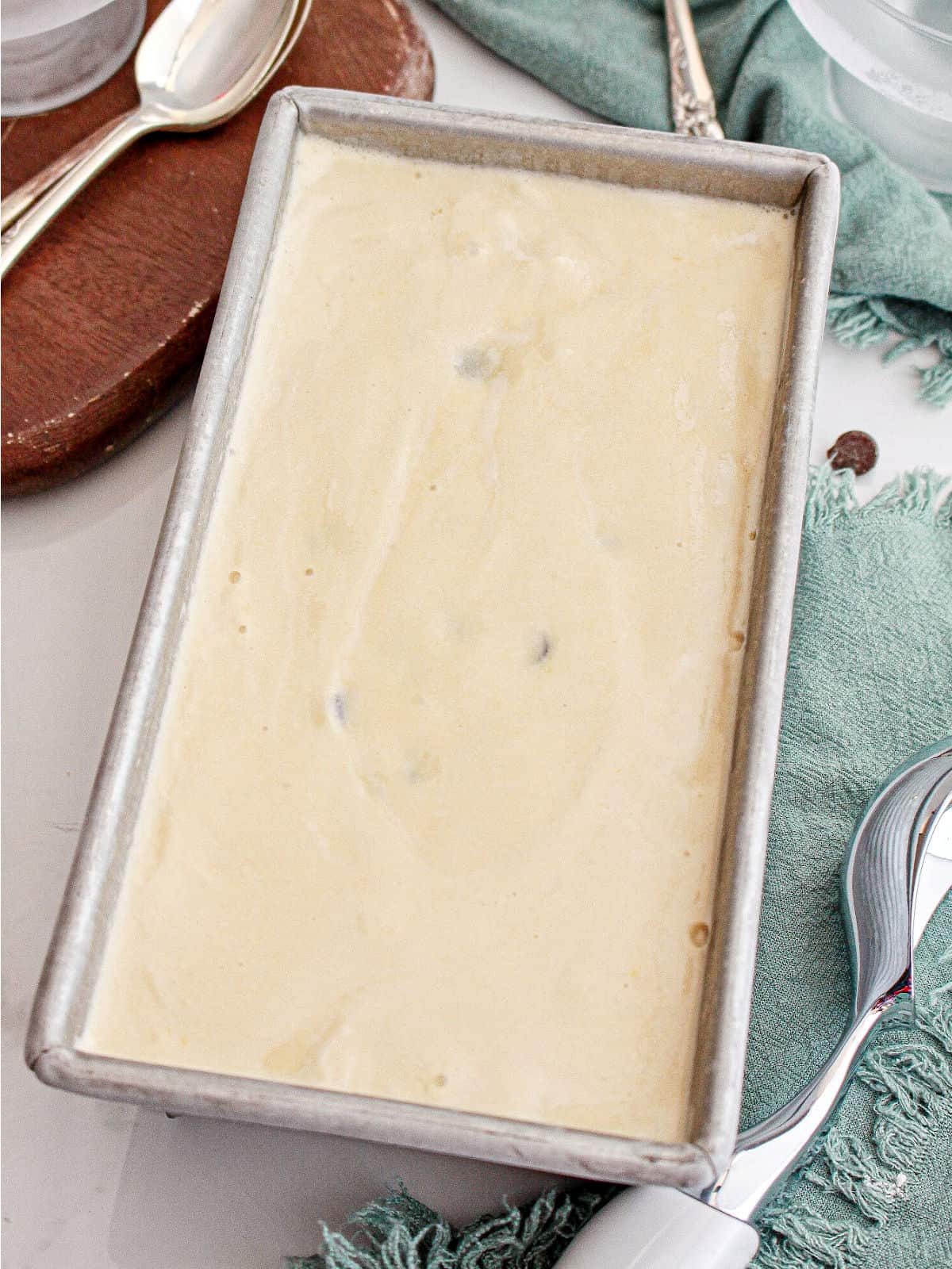 Metal loaf with chocolate chip cookie ice cream. White, wooden and green background.