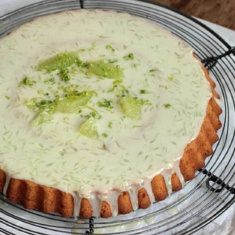 Wire rack with coconut cake with lime frosting.