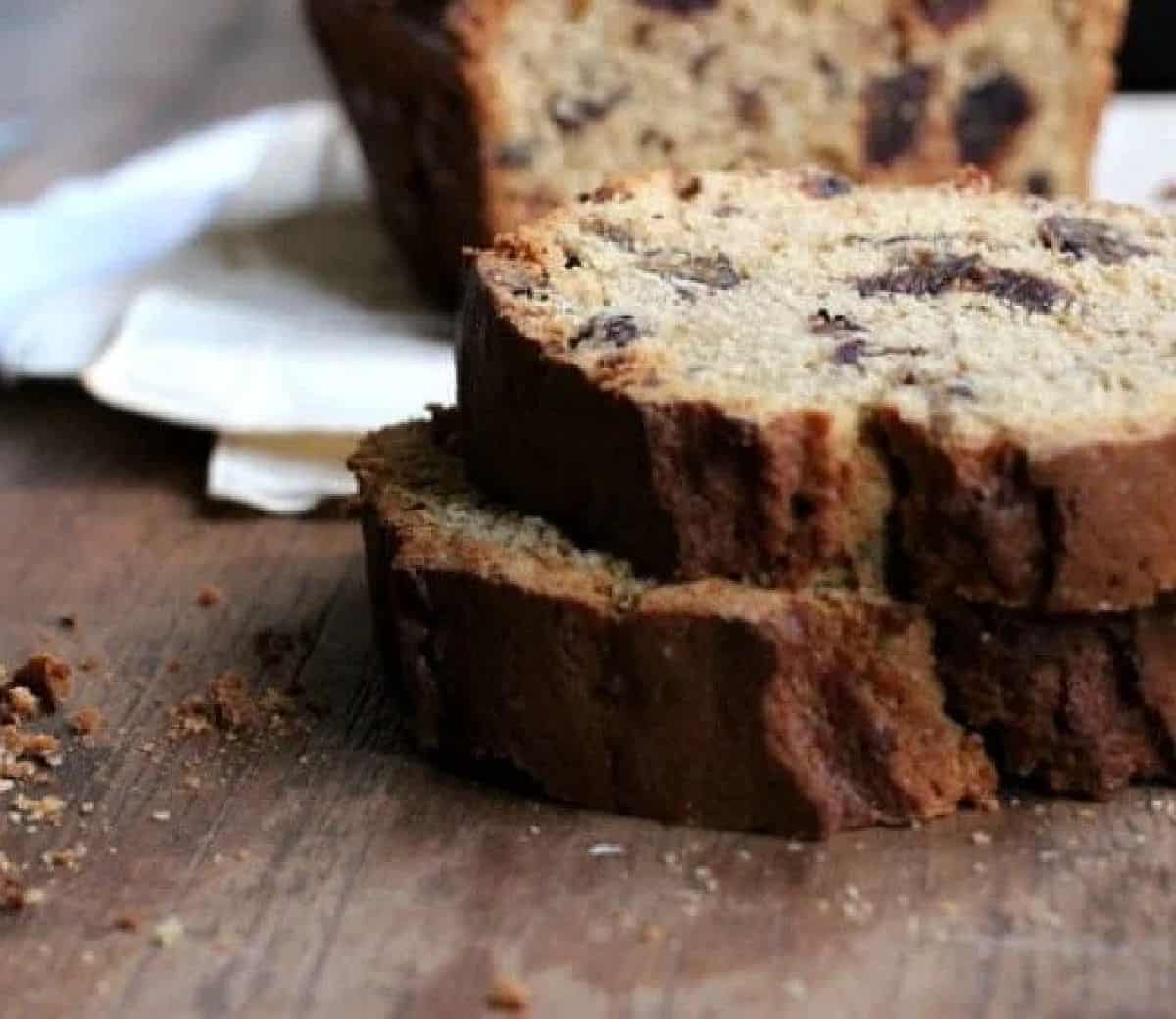 Two slices of date bread on a wooden table. 