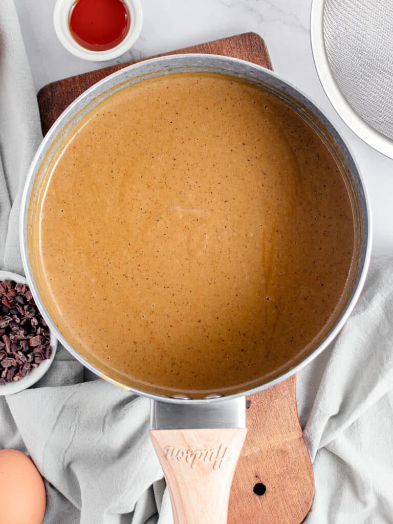 Top view of saucepan with coffee cream custard mixture. Gray background.