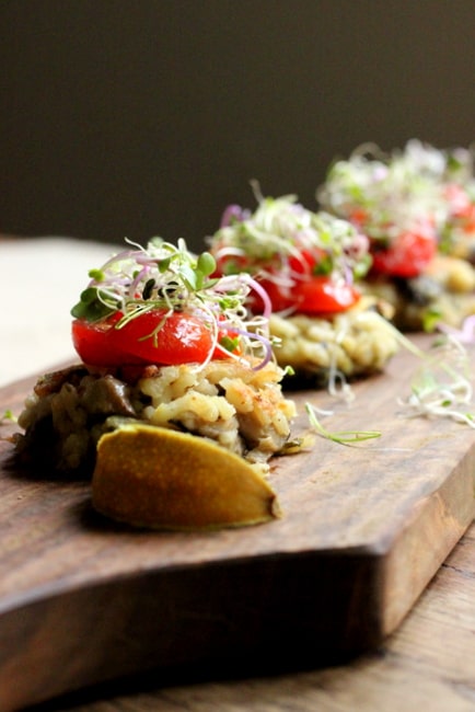 Several risotto cakes on long wooden board